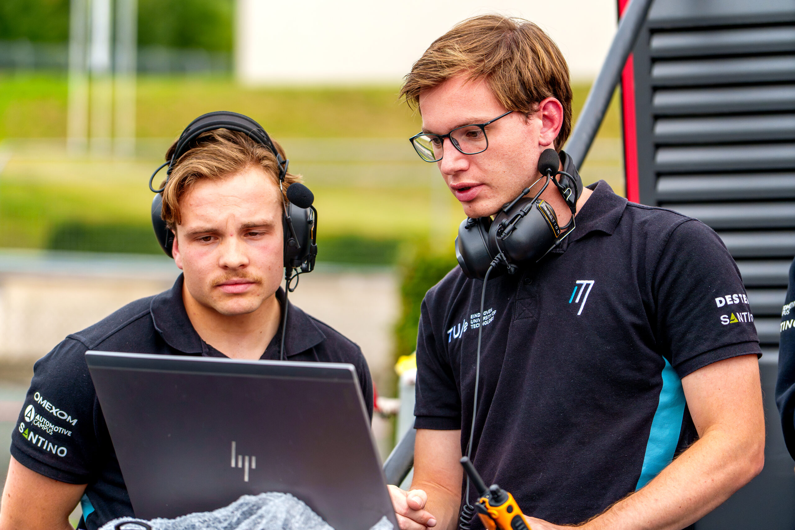 Twee InMotion-engineers met headsets bekijken de telemetrie op een laptop